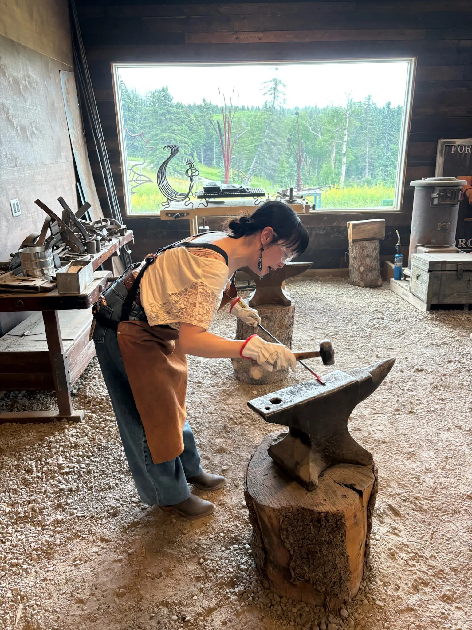 A guest shaping hot steel on an anvil