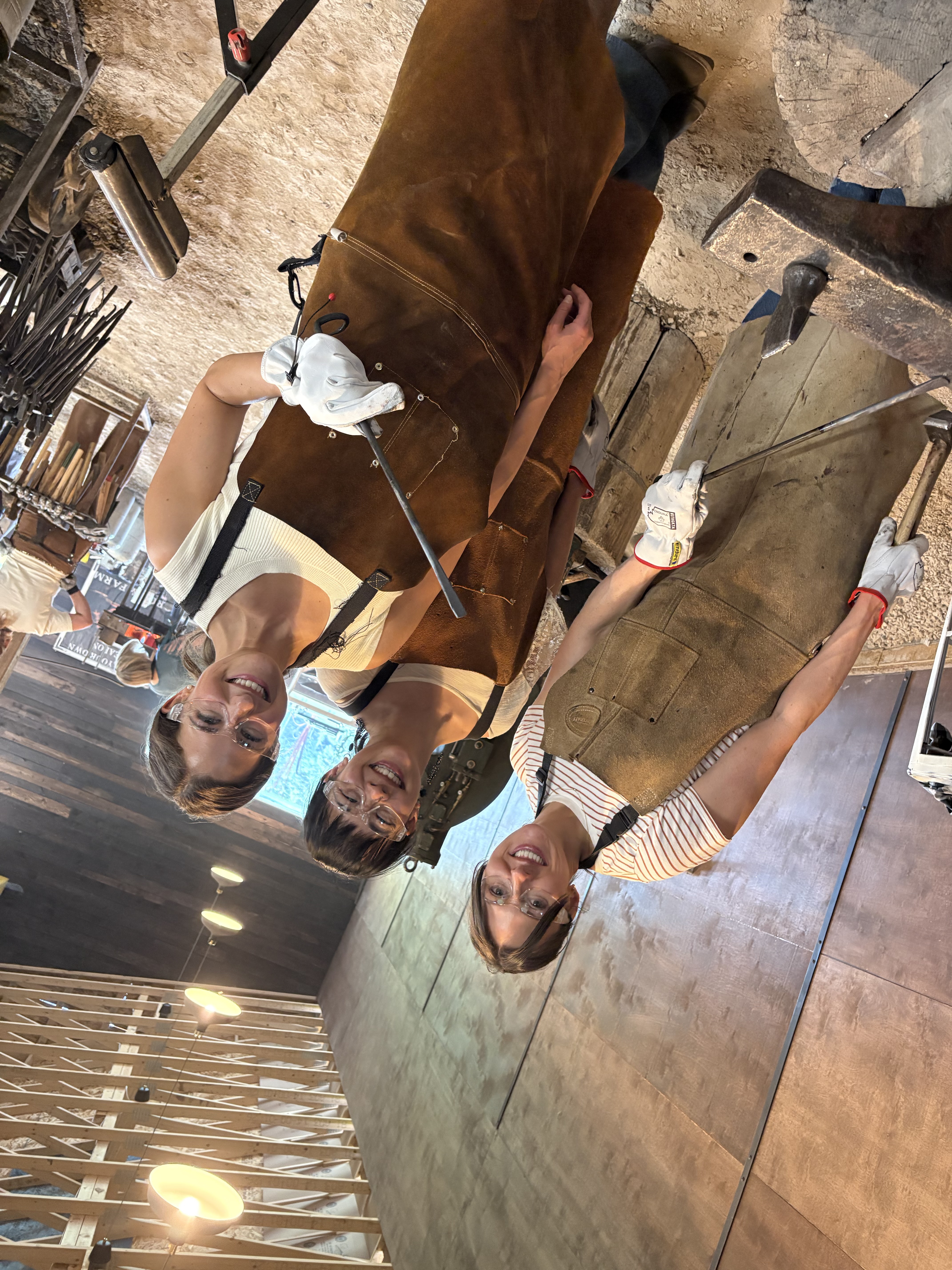Three guests posing together in their forge aprons