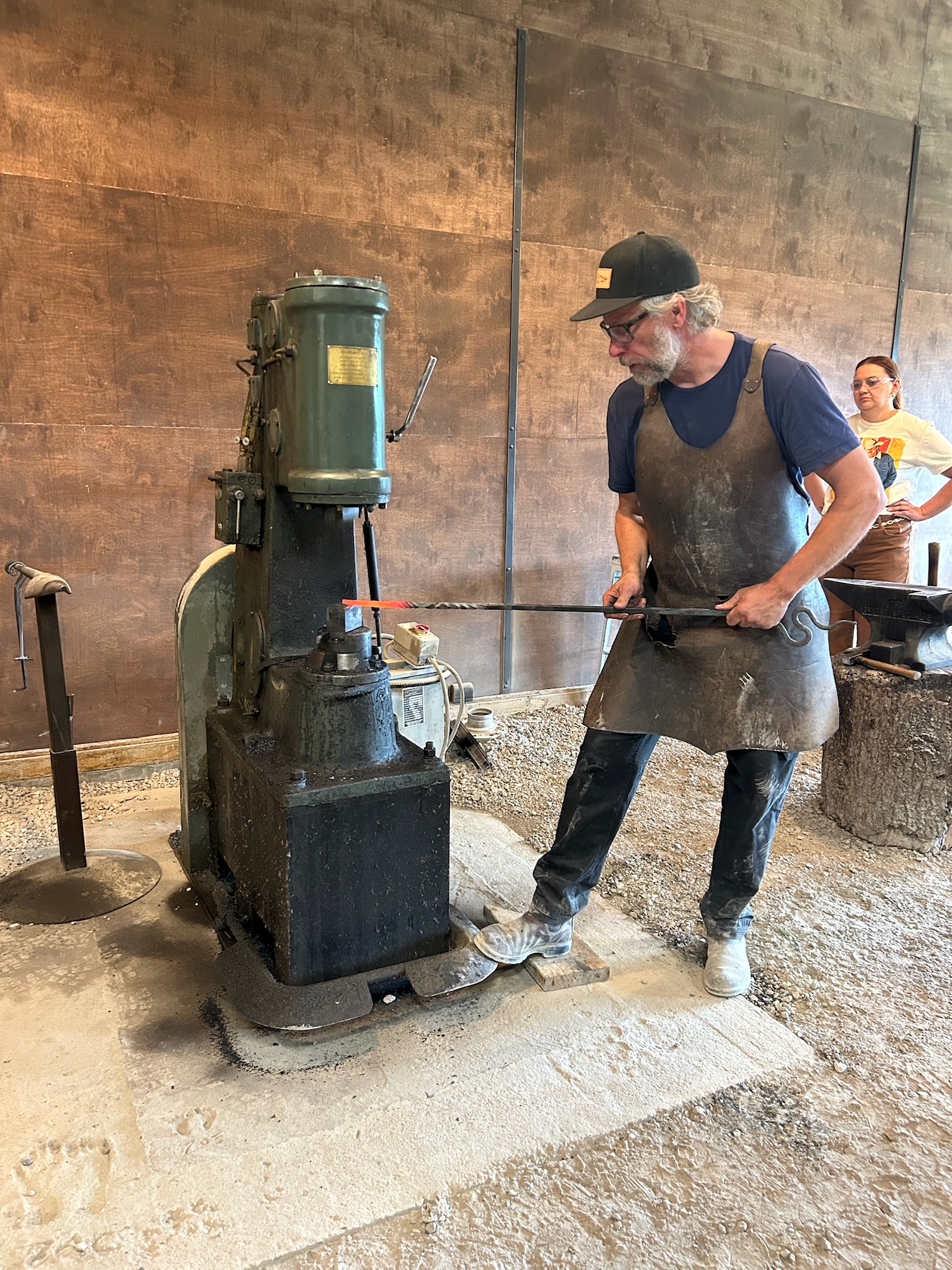 A blacksmith working at the power hammer