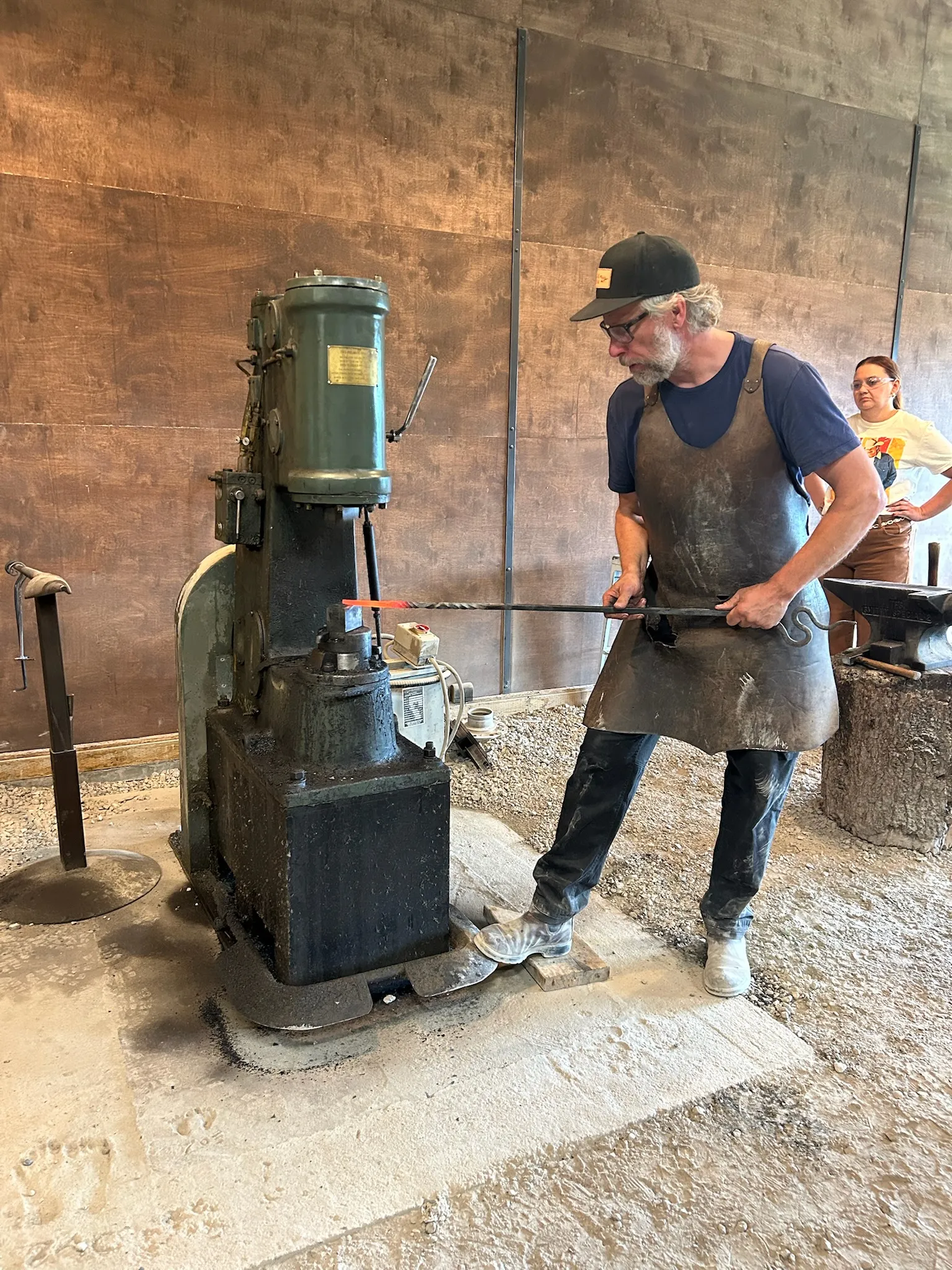 A blacksmith working at the power hammer